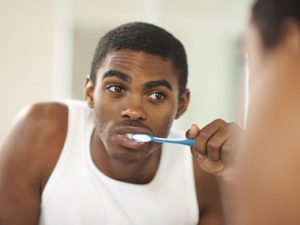 Black man brushing teeth